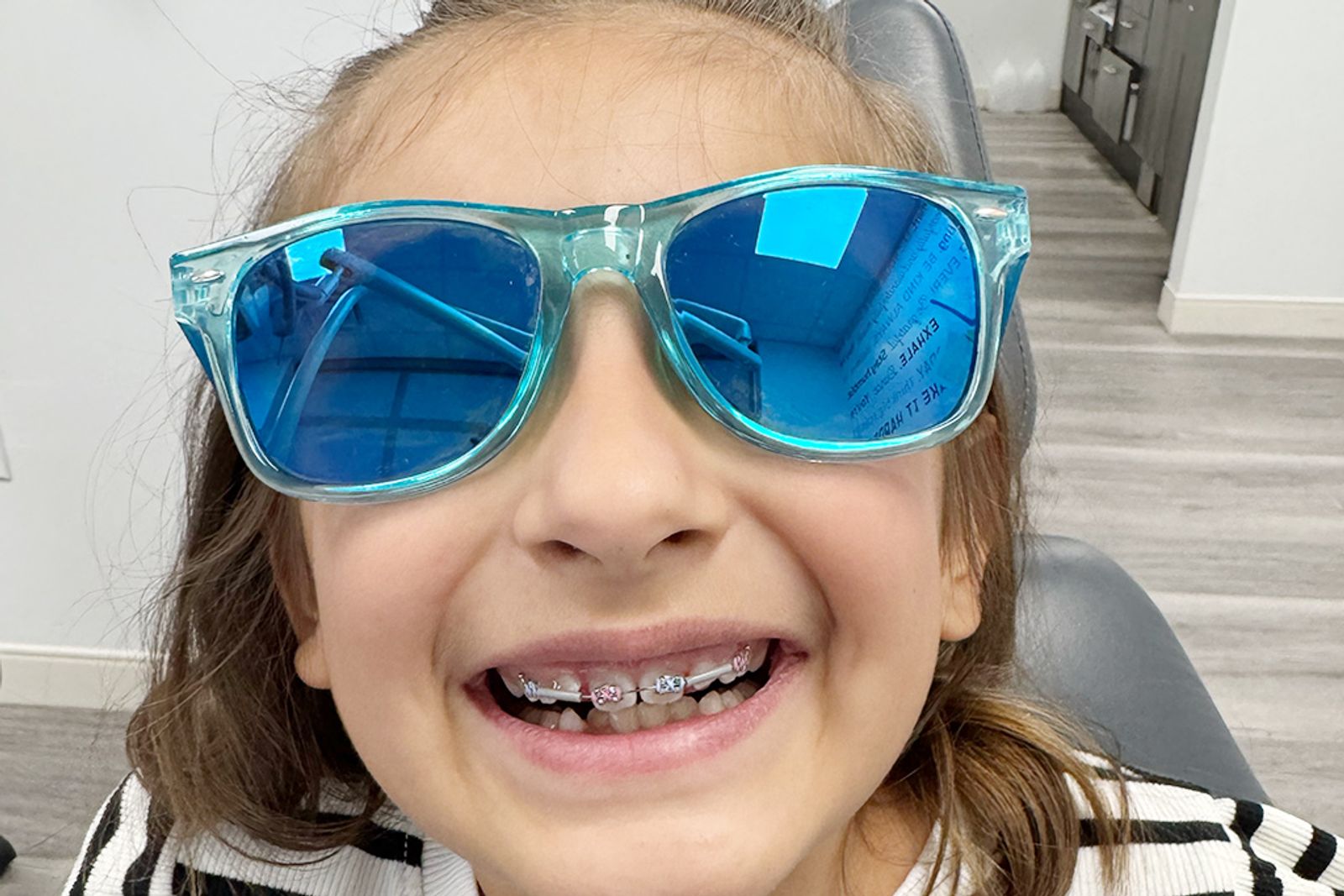 A young patient showing off colored braces